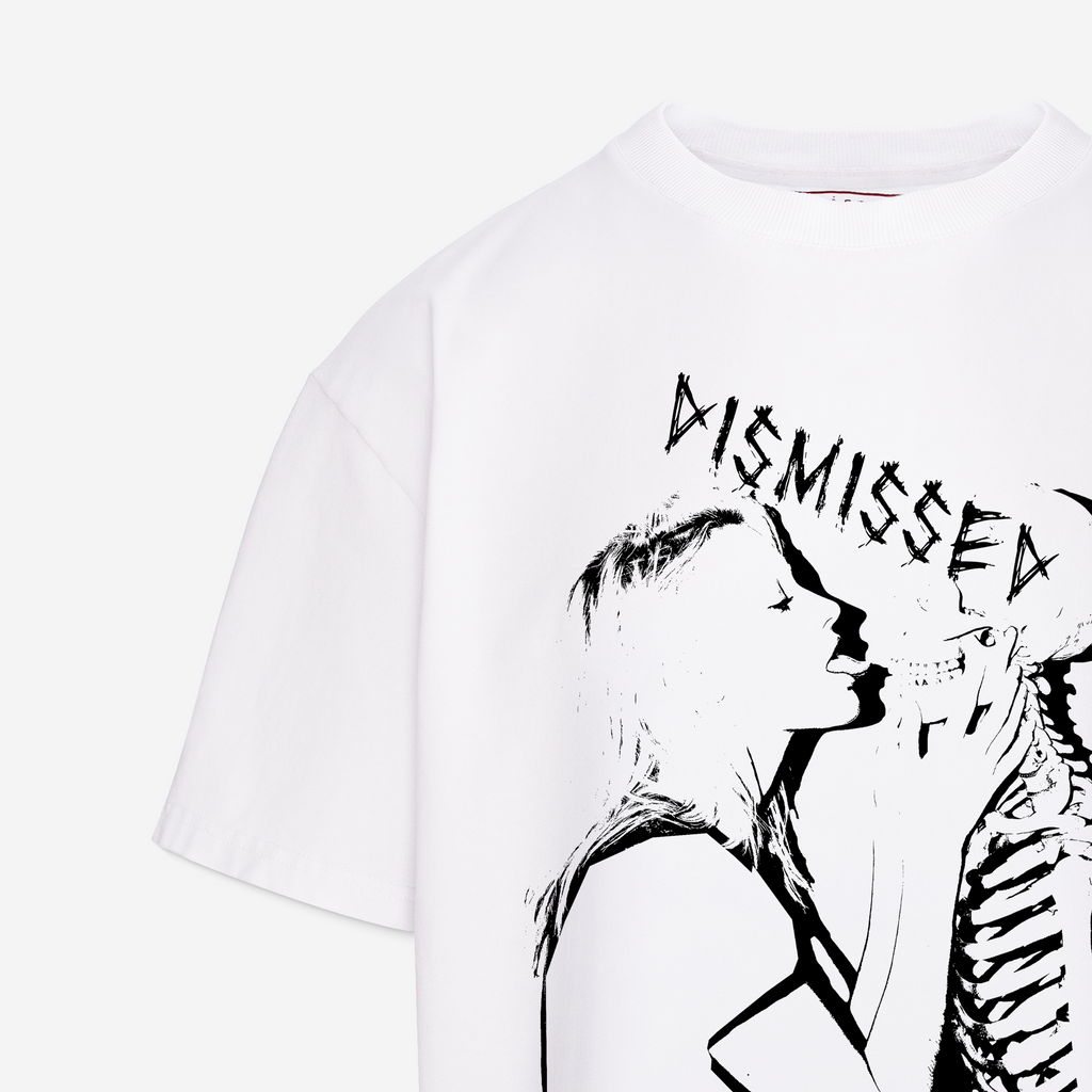 White short-sleeve graphic T-shirt with a black line art print of a woman, a skeleton, and the word 'DISMISSED' across the chest, shown on a light gray background.